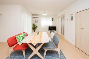 a dining room with a table and two chairs at kafuulivimg sobe in Yomitan