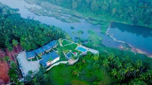 an aerial view of a house on a hill next to a lake at Pakalakam Resorts in Cheruppulasseri