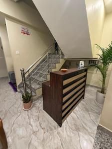 a lobby with a staircase with potted plants at Jogi Lodge in Varanasi