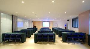 a room with blue tables and chairs and a screen at GreenTree Inn Fujian Fuzhou Software Park River View Business Hotel in Fuzhou