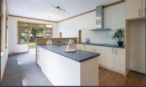 a kitchen with white cabinets and a blue counter top at Cambria Cottage in Nelson