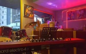 a room with drums and a bar with pink lights at Super Hostel in Nonthaburi