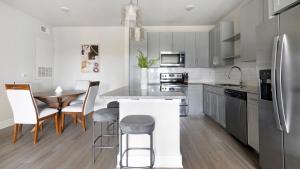 a kitchen with white cabinets and a table and chairs at Landing Apartments Jacksonville - Downtown Saint Johns in Sampson