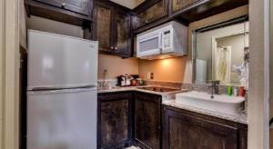 a kitchen with a white refrigerator and a sink at Americas Best Value Inn and Suites IAH Airport North in Houston +127 photos