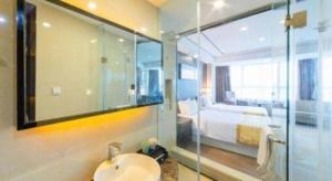a bathroom with a sink and a bed in a room at Ramada by Wyndham Wuhu in Wuhu +48 photos