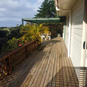 une terrasse couverte d'une maison avec une terrasse en bois dans l'établissement Tealuca Holiday Home, à Ngataki