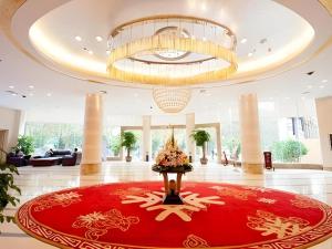 a lobby with a large red rug and a chandelier at Kunming Wenhui Hotel in Kunming
