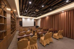 a conference room with tables and chairs and a screen at James Joyce Coffetel Tianjin Railway Station Jinshiqiao Metro Station Branch in Tianjin