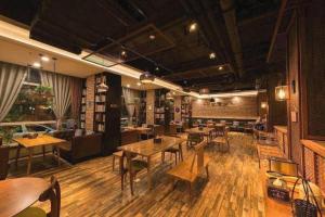 a restaurant with tables and chairs in a room at James Joyce Coffetel Tianjin Railway Station Jinshiqiao Metro Station Branch in Tianjin