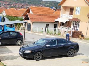 a black car parked next to a bus stop at BakaBaka in Pojate