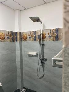 y baño con ducha y cabezal de ducha. en Rhythm Transit Hotel - Near Airport, en Katunayake