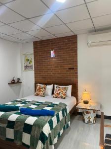Un dormitorio con una cama y una pared de ladrillo. en Rhythm Transit Hotel - Near Airport, en Katunayake