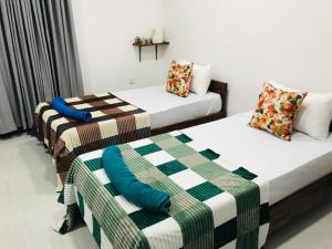 two beds in a hotel room with sidx sidx sidx sidx at Rhythm Transit Hotel - Near Airport in Katunayaka