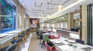 a restaurant with tables and chairs and a bar at Magnotel Shanghai Maglev Station in Shanghai
