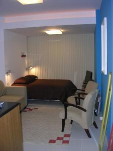 1 dormitorio con 1 cama, escritorio y sillas en Copa Apartments, en Río de Janeiro