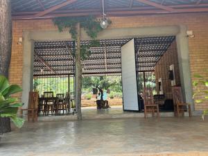 an open door to a patio with tables and chairs at Elephant Arcade Yala in Tissamaharama