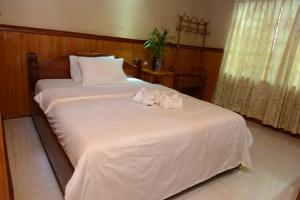 1 dormitorio con 1 cama con 2 toallas en Javier Guesthouse en Tbeng Meanchey