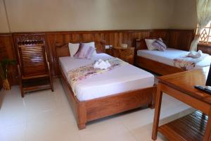 a bedroom with two beds and a table at Javier Guesthouse in Tbeng Meanchey