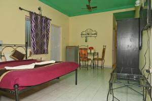 a bedroom with a bed and a table with chairs at Libton Manor in Candolim