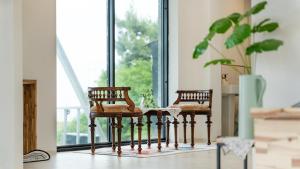 two wooden chairs sitting in front of a window at Gangneung Remember Dogchae Pension in Gangneung