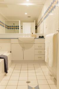 ニューカッスルにあるBeachfront Getaway with Views, Pool & Tennis Courtの洗面台と鏡のある白いバスルーム