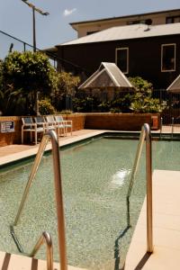 ニューカッスルにあるBeachfront Getaway with Views, Pool & Tennis Courtの水中に2本の金属製レールがあるスイミングプール