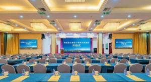 a conference room with tables and chairs and a screen at Xiamen Plaza Hotel in Xiamen