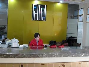 a woman sitting at a counter in an office at Zhangjiajie Fulante News Business Hotel in Zhangjiajie