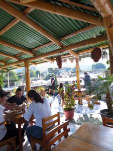 a group of people sitting at tables in a restaurant at Golden Bird in Mindo