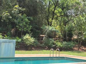 a swimming pool with two metal faucets in a yard at Elephant Arcade in Tissamaharama