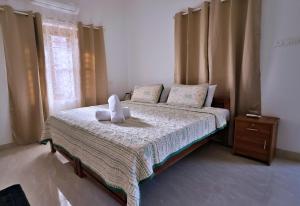 a bedroom with a bed with two stuffed animals on it at Gypsy Walker Plus in Varkala