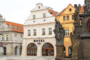 budynek hotelowy z pomnikiem przed nim w obiekcie Hotel U Hada Žatec w mieście Žatec