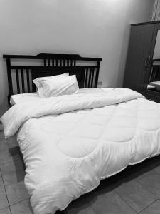 a large bed with white sheets and pillows at KiGALI HORIZON HOMES in Kigali