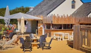 Un patio con sillas y mesas y un edificio. en Mobilhome 3 chambre à 2 pas de la plage, en Sarzeau