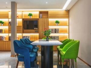a conference room with a table and green chairs at Jinjiang Inn Wuhan Linjiaohu Wanda Branch in Wuhan