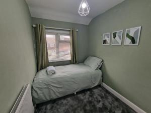 a small bed in a room with a window at Shugborough House in Stafford +7 photos