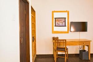 una habitación con un escritorio con televisión y una silla en Janitra 1 BR Standar Room ZN304, en Gili Air