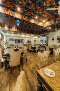 ブリンダーバンにあるThe Ruby Resort, Vrindavan # Prime Location # Luxury Rooms # Near Prem Mandir # Restaurant # Big Lawn # Big Parking # By Nandan Group #のテーブルと椅子があり、天井が描かれたダイニングルーム