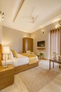 a bedroom with a large bed and a tv at The Ruby Resort, Vrindavan # Prime Location # Luxury Rooms # Near Prem Mandir # Restaurant # Big Lawn # Big Parking # By Nandan Group # in Vrindāvan