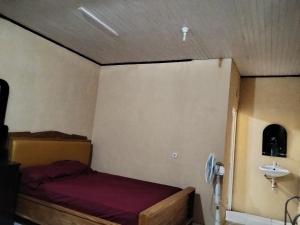 a small bedroom with a bed and a sink at Homestay Mamalis in Bunaken