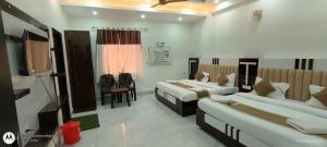 a room with two beds and a desk in it at Girbar Dhaam Near By Prem mandir in Vrindāvan