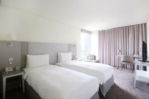 a hotel room with two beds and a desk at Ambience Hotel Taipei in Taipei +52 photos