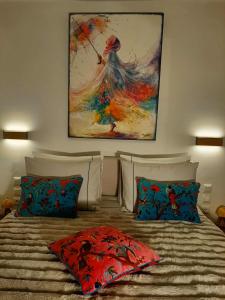 a bed with two pillows and a painting on the wall at Ioni Home in Tsagarada