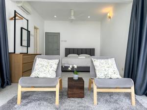 1 dormitorio con 2 sillas y 1 cama en Modern Garden View Bungalow In Seremban by Maison, en Seremban