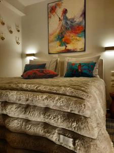 a bedroom with a bed with a painting on the wall at Ioni Home in Tsagarada