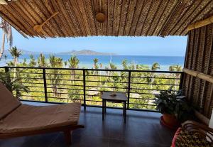 a room with a balcony with a view of the ocean at LE CHISSIOUA in Sada