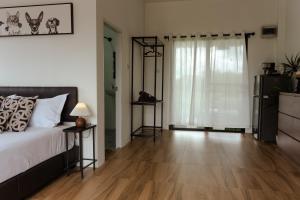 Un dormitorio con una cama y suelo de madera. en Lalaland CD, en Ban Mae Khon