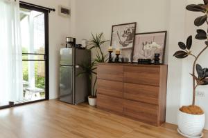 Habitación con nevera y tocador de madera. en Lalaland CD, en Ban Mae Khon