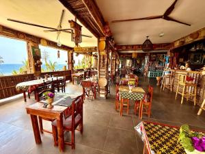 a restaurant with tables and chairs and the ocean at LE CHISSIOUA in Sada