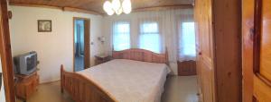 a bedroom with a bed and a tv and windows at Guesthouse Sekvoia in Smolyan